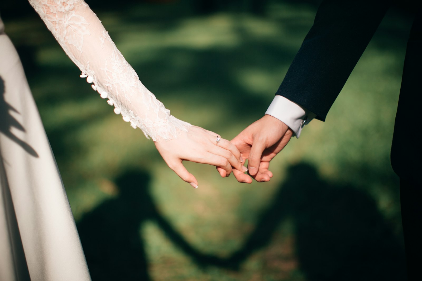 Two hands held together, casting a shadow on the grass