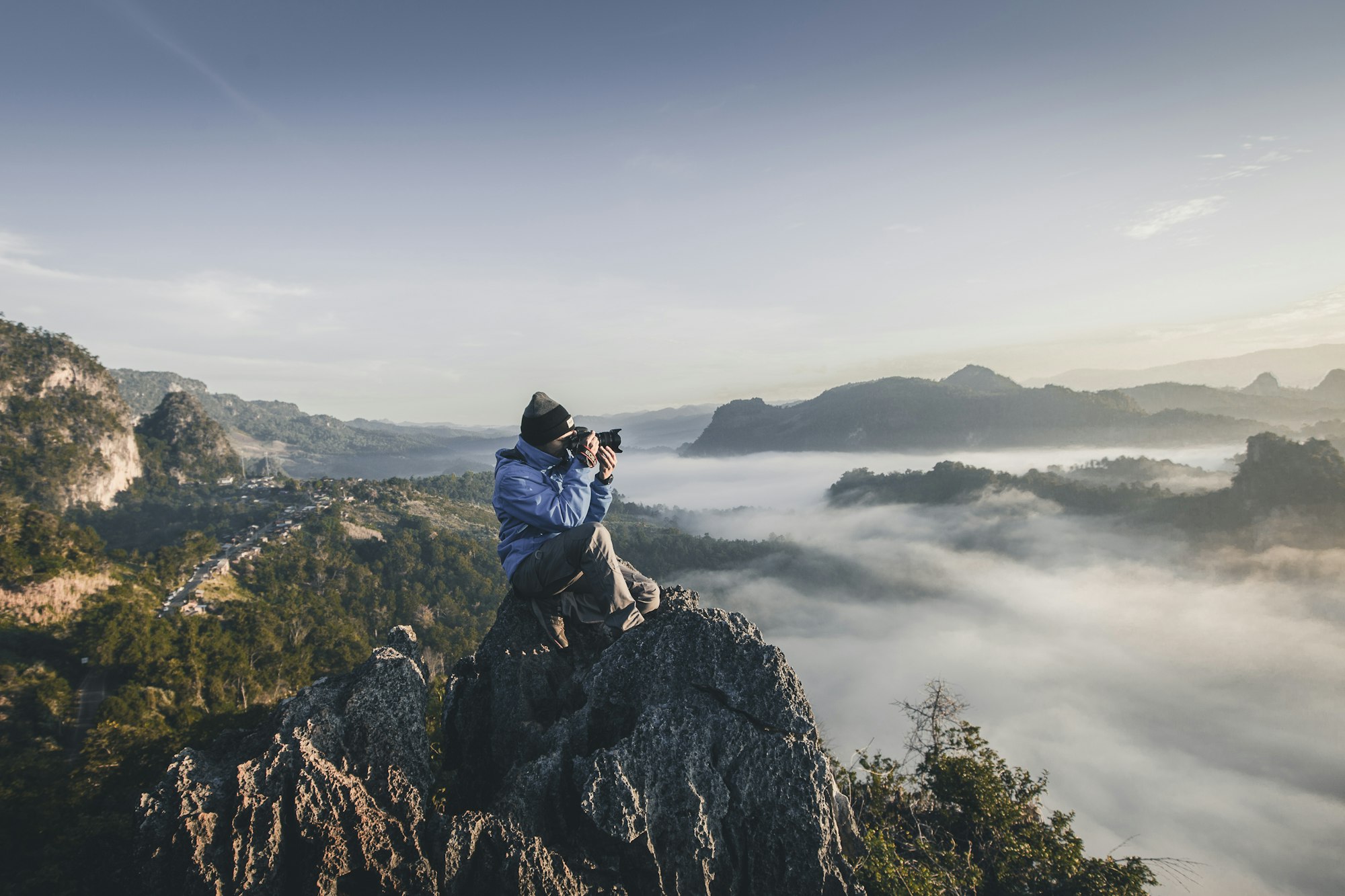 Un fotografo su un crinale sopra un mare di nebbia mattutina